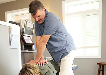 Dr. Blair Neely, DC - STRATFORD CHIROPRACTIC & WELLNESS CENTRE - Stratford, ON Chiropractors - Doctor With Patient Image