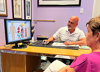 Dr. Harnek Gill, DC - CITY CENTRE CHIROPRACTIC - Mississauga, ON Chiropractors - Doctor Working Image